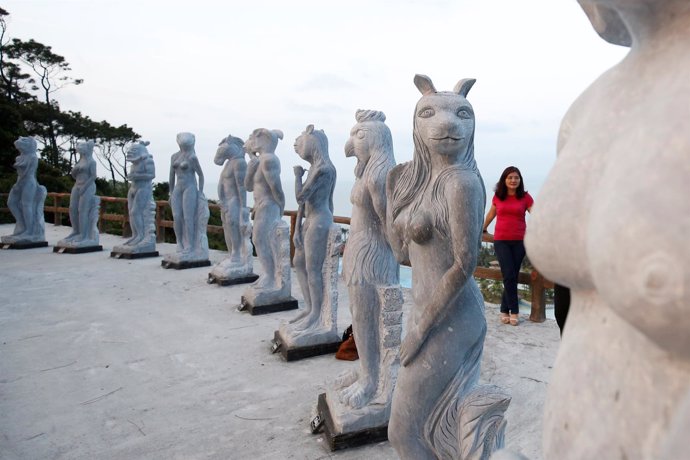 Una mujer posa junto a las polémicas estatuas en la ciudad de Hai Phong.