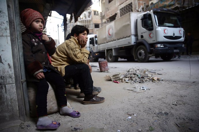 Niños junto a un convoy de ayuda en Duma, en Ghuta