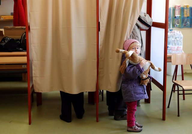 Una niña espera en un colegio electoral de Hungría. 