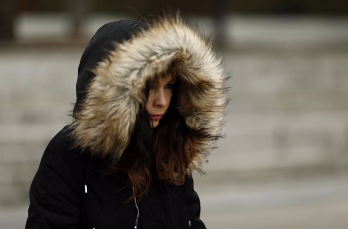 Una joven camina por la calle un día de invierno 