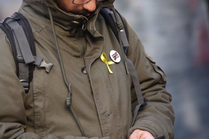 Una persona con lazo amarillo y chapa de libertad para los presos políticos