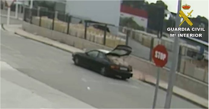 Coche deportivo circulando con el maletero abierto