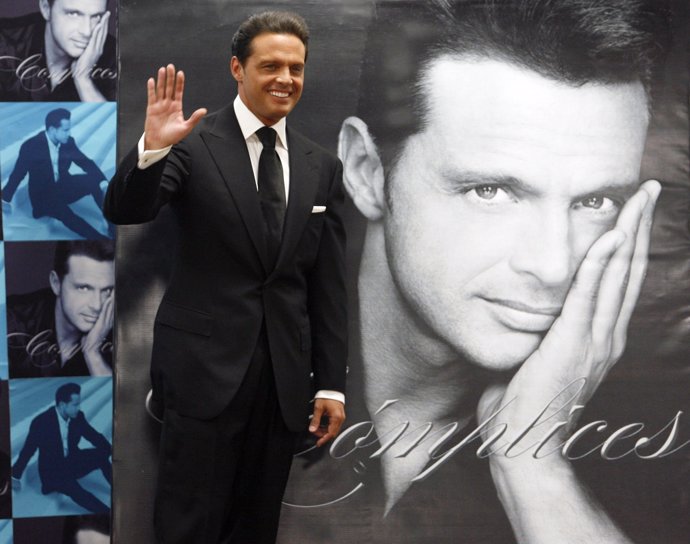 Mexican singer Luis Miguel poses next to a poster of himself during a photocall 