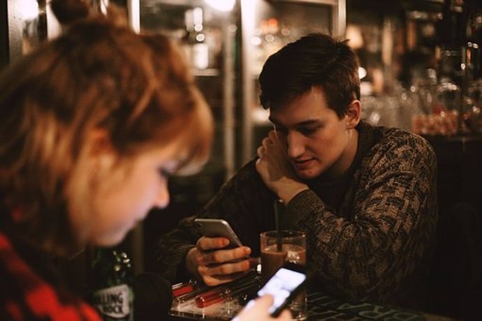 Dos personas mirando el móvil 
