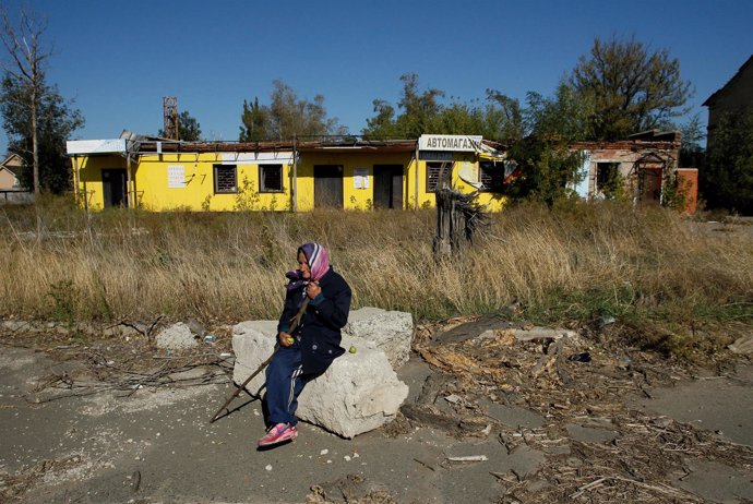 Una mujer sentada en un edificio abandonado en Donetsk