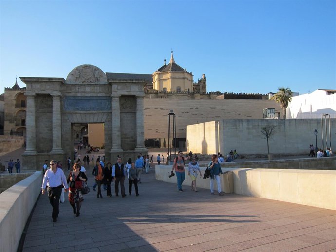 Turistas pasean por el Puente Romano