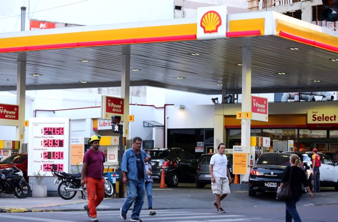 People walk in front of a Shell gas station in Buenos Aires, Argentina, March 12