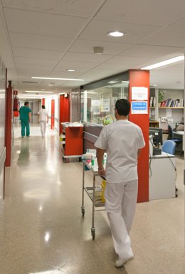 Un enfermero lleva un carrito de medicamentos.
