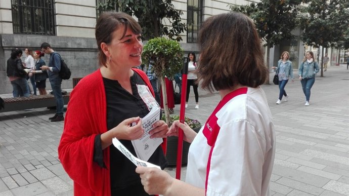 Elena Cortés reparte información del 1º de Mayo a una empleada de la limpieza
