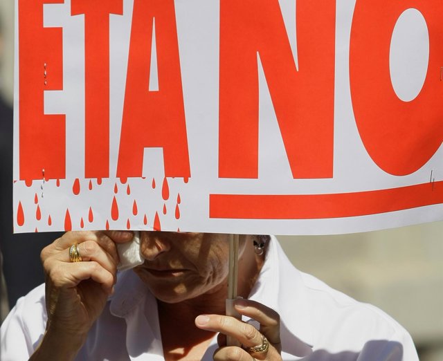Una mujer mantiene una pancarta "No a ETA" durante una manifestación en Madrid