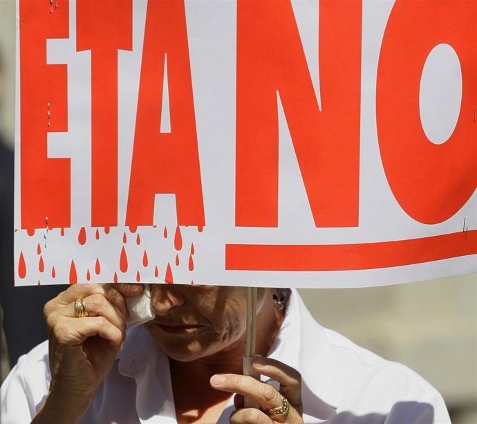 Una mujer mantiene una pancarta "No a ETA" durante una manifestación en Madrid