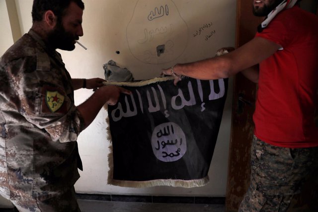 Las Fuerzas Democráticas Sirias con una bandera de Estado Islámico en Raqqa