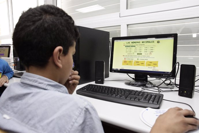 Alumno en clase con un ordenador. Imagen de archivo. 