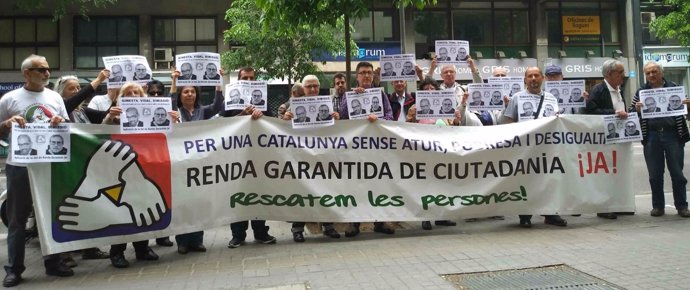 Protesta de promotores de la RGC ante una oficina de la Generalitat
