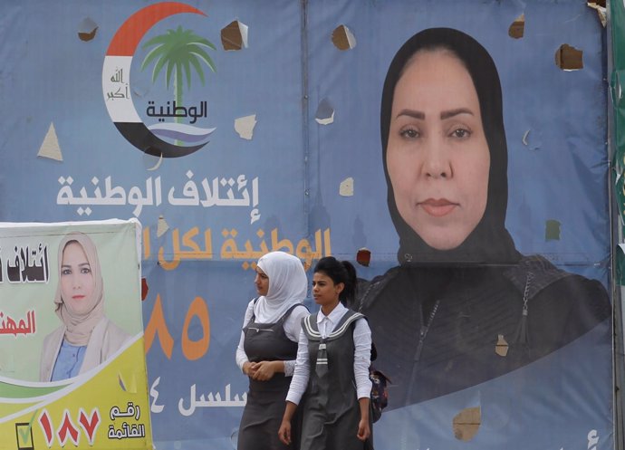 Niñas delante de poster electorales de mujeres candidatas en Irak
