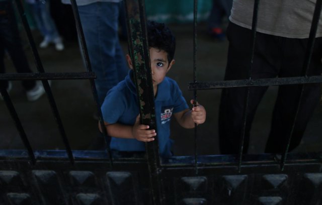 Niño palestino espera para viajar a Egipto en el paso de Rafá