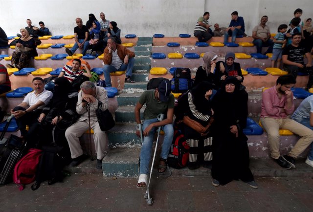 Palestinos esperando para cruzar el paso de Rafá