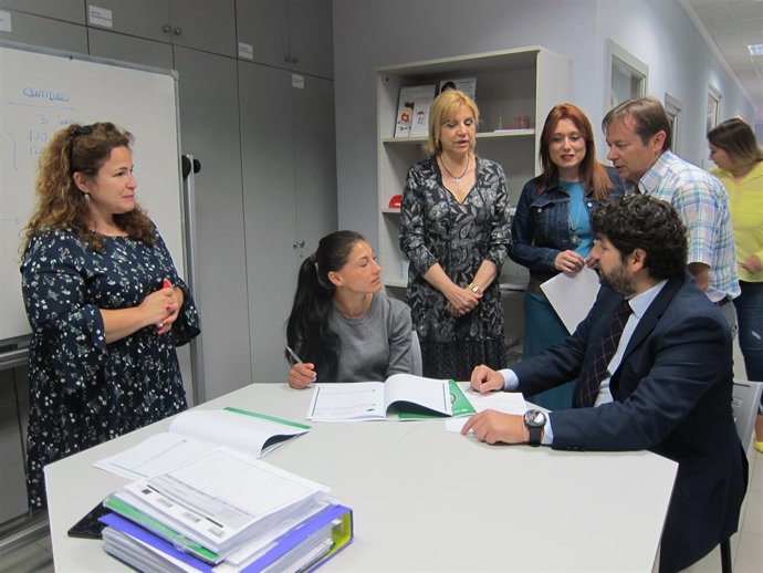 López Miras, sentado junta a una alumna de la Fundación Secretariado Gitano