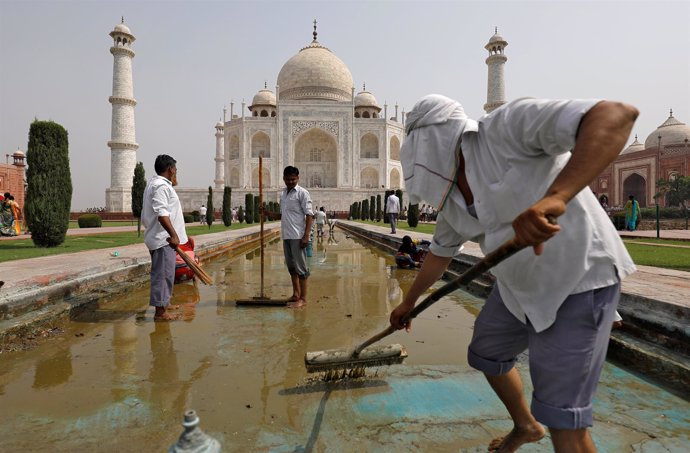 Trabajadores limpian la fuente en el Taj Mahal