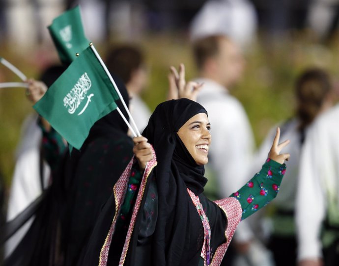 Una mujer saudí sosteniendo la bandera de su país
