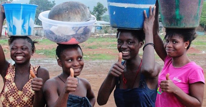 Mujeres africanas portan cubos sobre sus cabezas