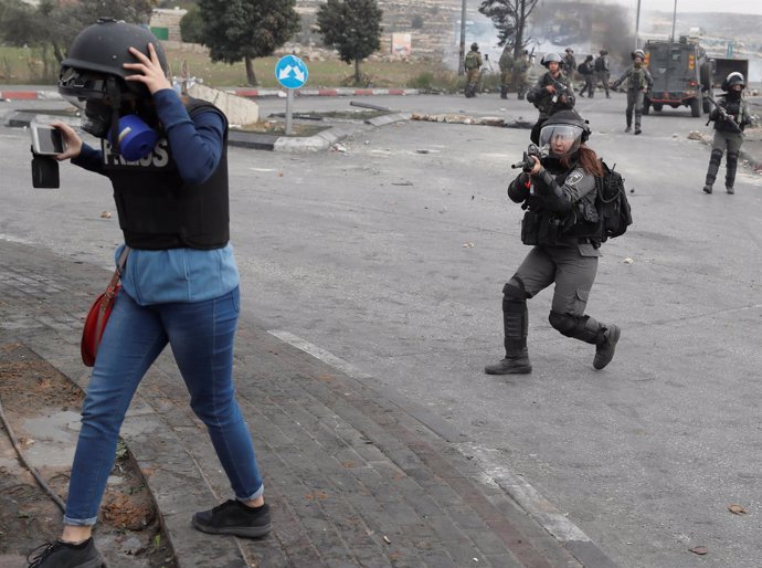 Una policía israelí apunta a un periodista
