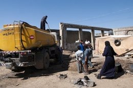Reparto de agua con un camión cisterna a refugiados sirios en Líbano