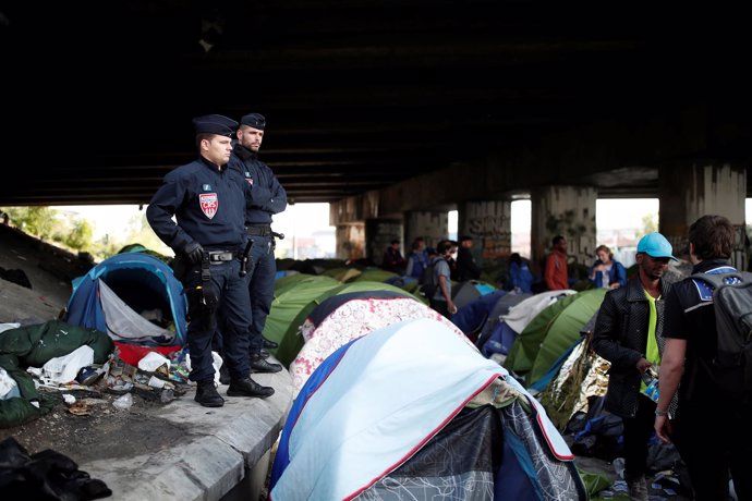 Policía francesa durante el desalojo de un campamento de inmigrantes en París