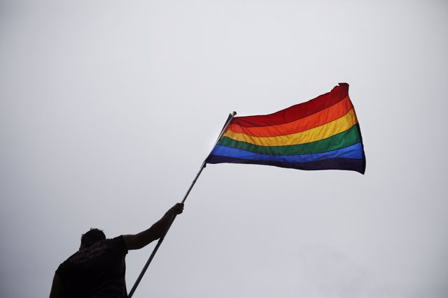 Un hombre sotiene una bandera LGTB