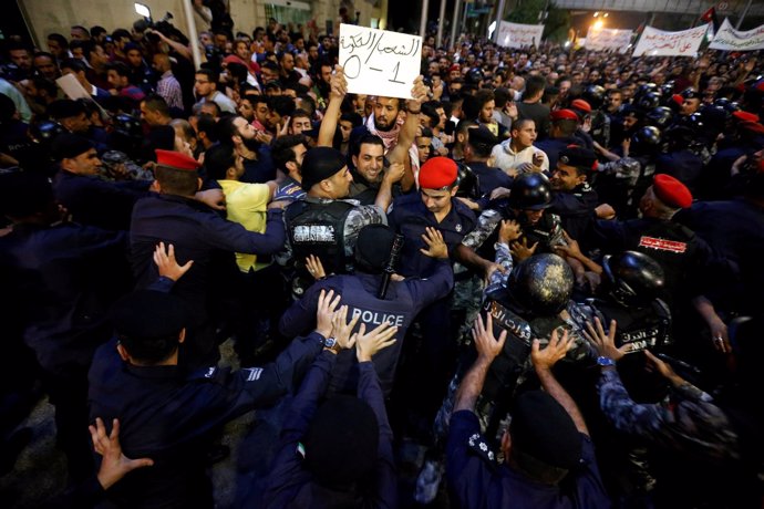 Manifestación en Amán y una pancarta que reza "Pueblo 1- Gobierno 0"
