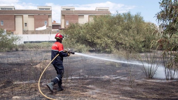 Un bombero acomete el refresco de la parcela afectada en Mutxamel