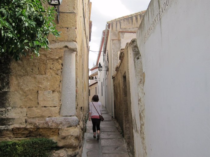 Una mujer pasea por una calleja del casco histórico de Córdoba