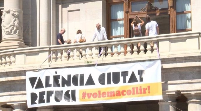 Joan Ribó en el balcón del Ayuntamiento junto a la pancarta de ciudad refugio 