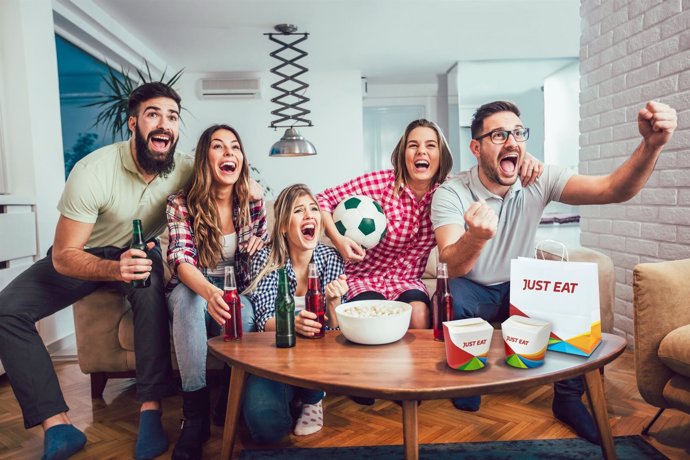 Gente animando partido de fútbol con comida a domicilio 