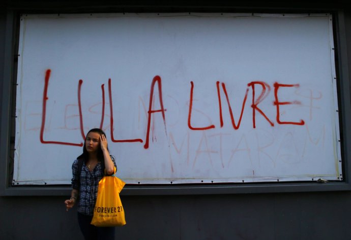 A woman stands in front of a sign reading: "Lula free" referring to  former Braz