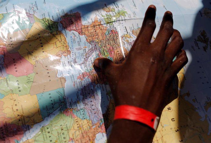 Un migrante señala un mapa tras ser rescatado en el Mediterráneo