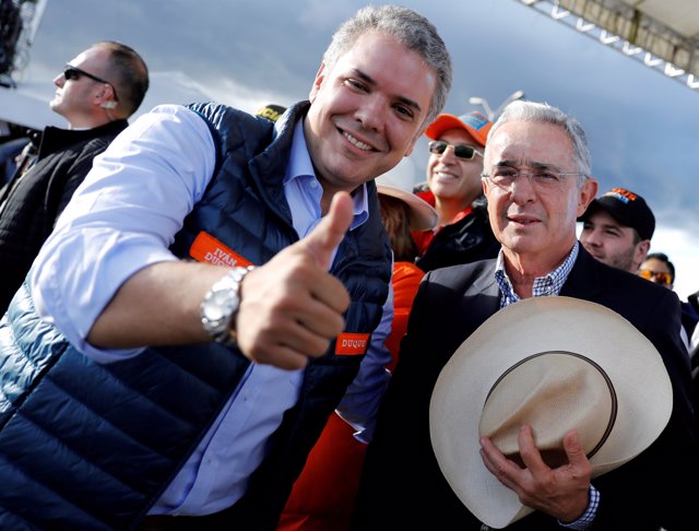 FILE PHOTO: Colombian former president Alvaro Uribe (R) and right-wing president