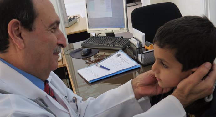 Un médico atiende a un niño en su consulta