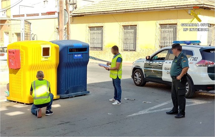 Tres agentes inspeccionan contenedores 