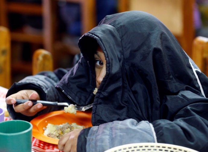 A child eats at the community youth center "Che Pibe" in Villa Fiorito, on the o