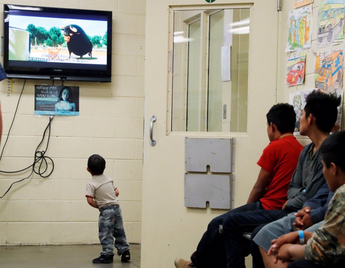 A detained immigrant child watches a cartoon while awaiting the arrival of U.S. 