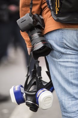 Fotógrafo con cámara y máscara de gas