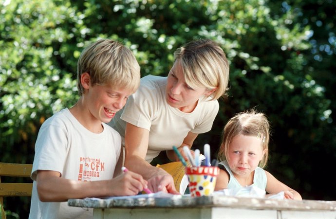 MADRE HACIENDO LOS DEBERES CON SUS DOS HIJOS