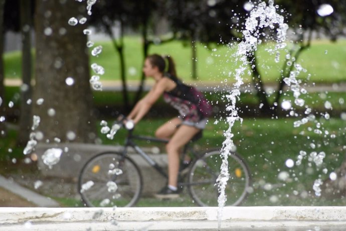 Chica en bicicleta y agua