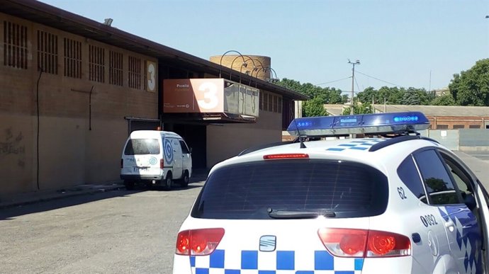 Un cotxe de la Guàrdia Urbana i una furgoneta d'Ilnet en els Camps Elisis