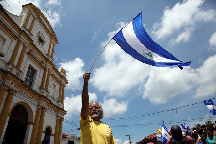 A man waves a national flag during a visit by Catholic leaders as anti-governmen
