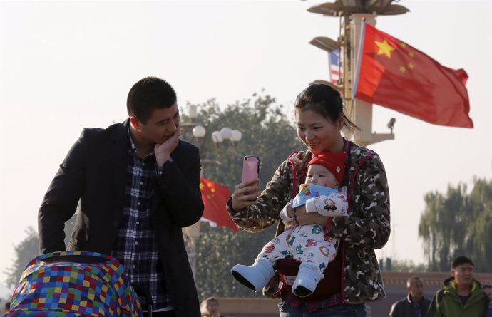 Una pareja china con su hijo en la plaza Tiananmen, en Pekín