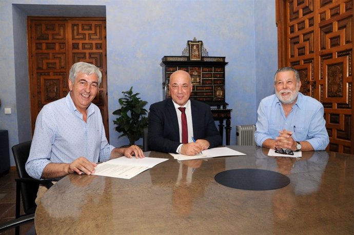 Antonio Ruiz (centro) firma el convenio