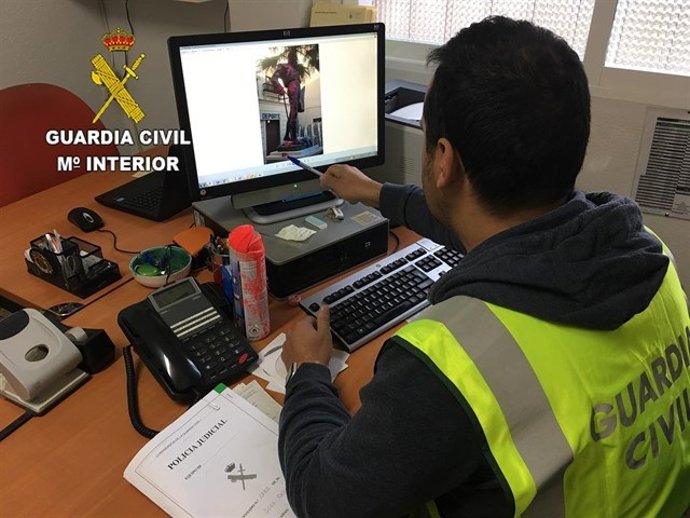 Un guardia civil frente a un ordenador con la imagen de la estatua pintada