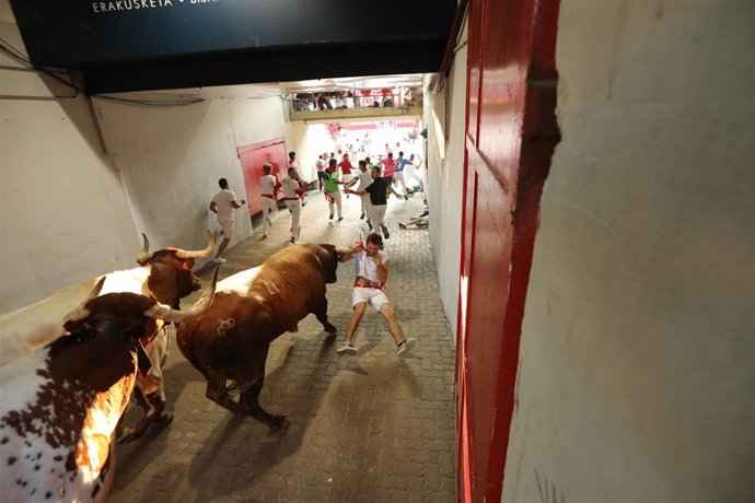 Corredor enganchado por el pañuelo en el encierro de Miura en Sanfermines.
